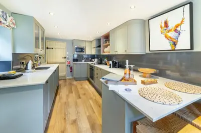 a large kitchen with blue cabinets and a large island at Poet's Corner in Grasmere