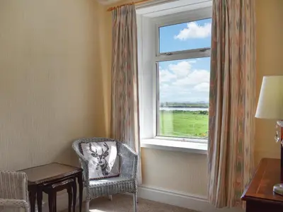 a room with a window with a chair and a desk at The Stables in Beckfoot