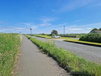 a road with a white car driving down the road at The Stables in Beckfoot
