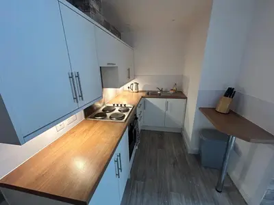 a kitchen with white cabinets and a stove top oven at Central apartments in Carlisle