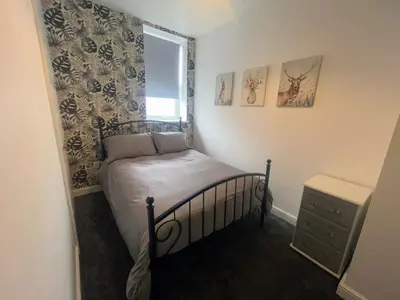 a small bedroom with a bed and a window at Central apartments in Carlisle