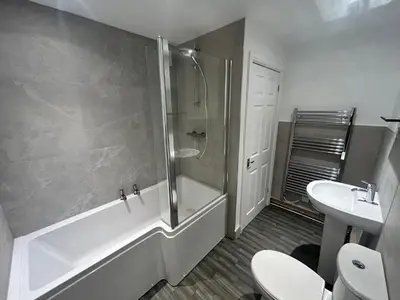 a bathroom with a shower and a toilet and a sink at Central apartments in Carlisle