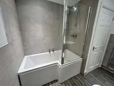a bathroom with a shower and a white tub at Central apartments in Carlisle