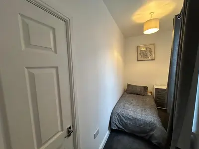a small bedroom with a bed and a door at Central apartments in Carlisle