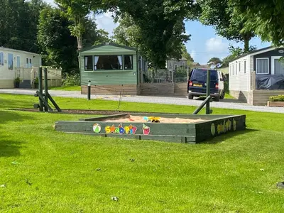 a sandbox in the grass in a park at 23 The Beeches in Gilcrux