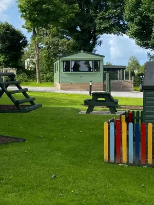 a park with a fence and a picnic table and a bench at 23 The Beeches in Gilcrux