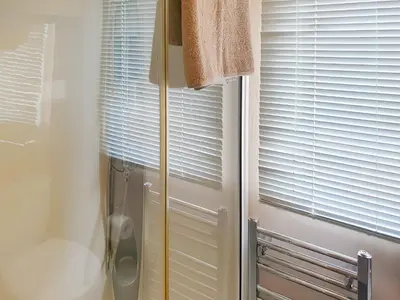 a shower in a bathroom next to a window at Stream Side View in Lamplugh