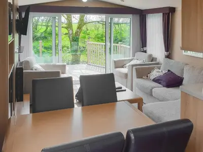 a kitchen and living room with a table and chairs at Stream Side View in Lamplugh