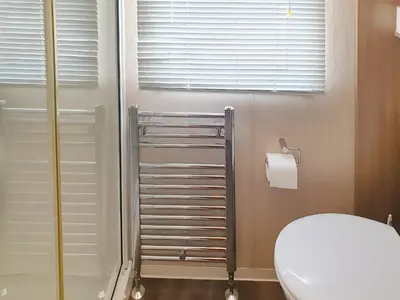 a bathroom with a white toilet and a shower at Stream Side View in Lamplugh