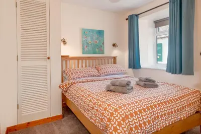 a bedroom with a bed with two towels on it at Courtyard Cottages Granary Cottage in Wigtown