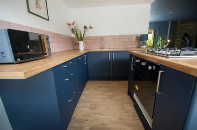 a kitchen with blue cabinets and a counter top at Bird Nest - dine with the eagles Private Retreat in Carlisle