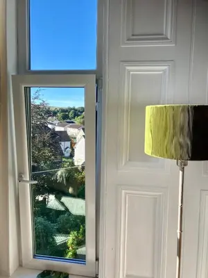 a door with a window with a view of a house at Above & Beyond at Warriston Lodge in Moffat