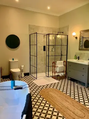 a bathroom with a shower and a tub and a sink at Above & Beyond at Warriston Lodge in Moffat