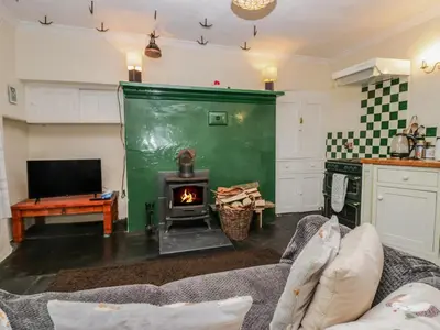 a living room with a couch and a fireplace at Gardeners Cottage in Millom