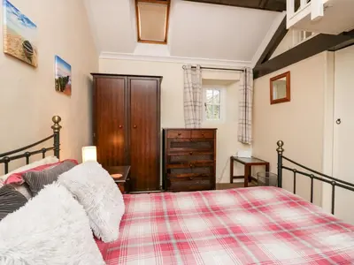 a bedroom with a bed and a dresser at Gardeners Cottage in Millom