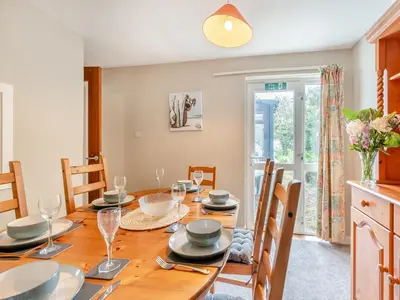 a dining room with a wooden table and chairs at Carraig-Dhubh South - Uk47124 in Whiting Bay
