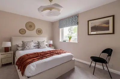 a bedroom with a bed and a chair and a window at Oakbank-Central Grasmere in Grasmere