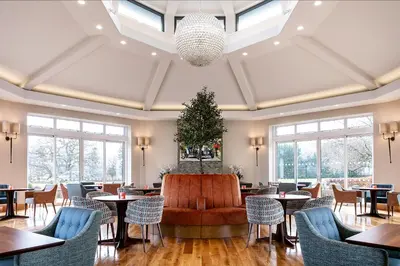 a restaurant with tables and chairs and a christmas tree at The Inn On The Lake in Glenridding