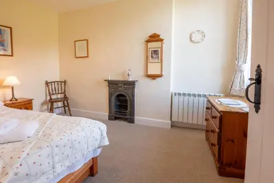 a bedroom with a bed and a fireplace at Myrtle Cottage in Chapel Stile