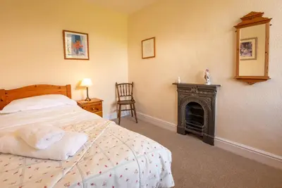 a bedroom with a bed and a fire place at Myrtle Cottage in Chapel Stile