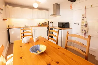 a kitchen with a wooden table with a bowl on it at Myrtle Cottage in Chapel Stile