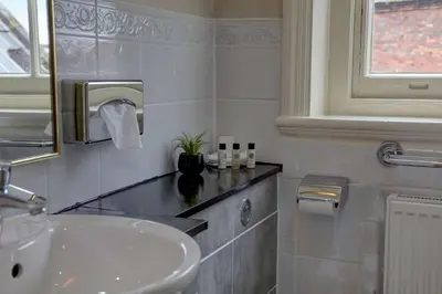 a white bathroom with a sink and a mirror at Crown & Mitre Hotel in Carlisle