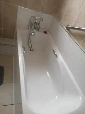 a bathroom with a bath tub with a shower head at Kumba in Kilmarnock