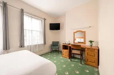 a hotel room with a desk and a mirror at The County Hotel in Carlisle