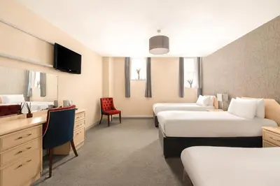 a hotel room with two beds and a desk at The County Hotel in Carlisle