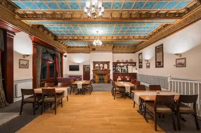 a dining room with tables and chairs and a fireplace at The County Hotel in Carlisle