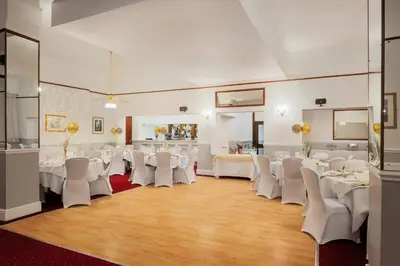 a banquet hall with white tables and white chairs at The County Hotel in Carlisle