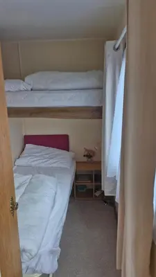 a small room with two bunk beds and a closet at Static Caravan situated at Wigbay, Stranraer in Stranraer