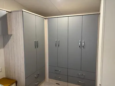 a closet with white cabinets in a room at Forestbrook - Cheerful two bedroom tiny house in Carlisle