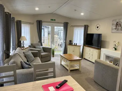 a living room with a couch and a tv at Forestbrook - Cheerful two bedroom tiny house in Carlisle