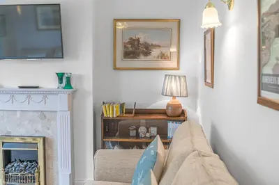 a living room with a couch and a fireplace at The Hytte, 19 Greta Grove House in Keswick