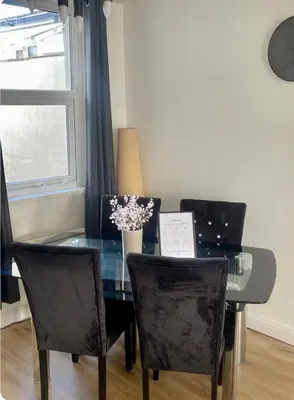 a dining room table with chairs and a vase of flowers at Birks road in Cleator Moor