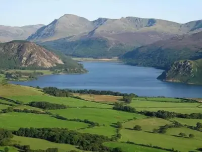 a view of a lake with mountains in the background at Birks road in Cleator Moor