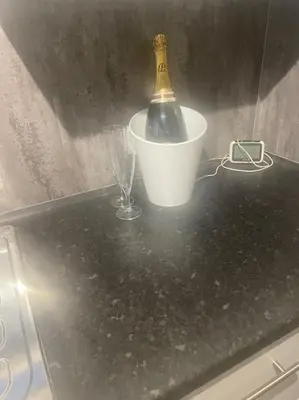 a black counter with a bottle and glasses on it at Birks road in Cleator Moor
