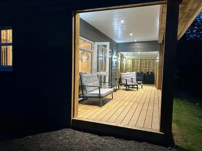 a mirror reflection of a patio with a chair and a table at Castle Glen Lodge in Dumfries