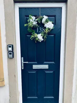 a blue door with a wreath of flowers on it at Queens Townhouse - 4 Bedrooms - Sleeps 9 in Whitehaven