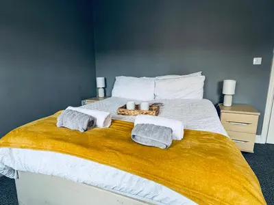 a bed with two towels and two candles on it at Queens Townhouse - 4 Bedrooms - Sleeps 9 in Whitehaven