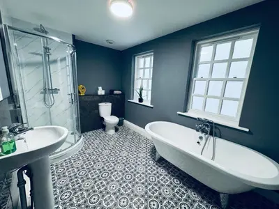a bathroom with two sinks and a tub and a toilet at Queens Townhouse - 4 Bedrooms - Sleeps 9 in Whitehaven