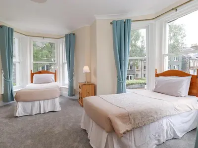 two beds in a room with two windows at Melbreak House 2 in Keswick