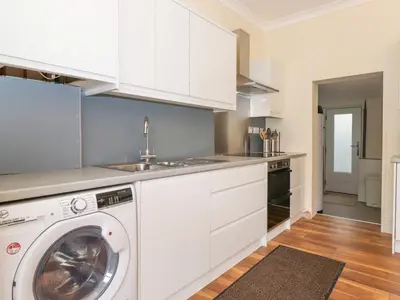 a white kitchen with a washing machine in it at Melbreak House 2 in Keswick