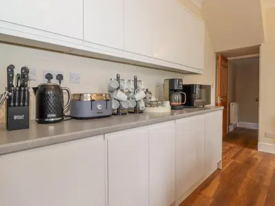 a kitchen with white cabinets and a counter top at Melbreak House 2 in Keswick