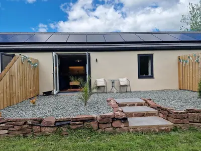 a house with a patio and a table and chairs at The Drey by Blake view holidays, a peaceful boutique retreat, 3 miles from Ennerdale- small twin or king bed available in Arlecdon