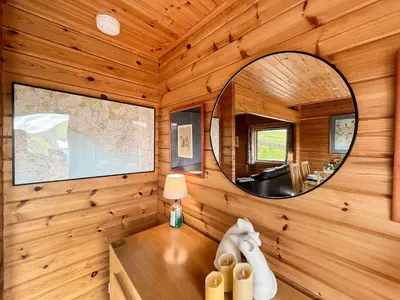 a mirror in the corner of a wooden room with a desk at Bengairn in Ringford