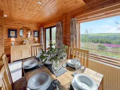 a dining room with a table and a large window at Bengairn in Ringford