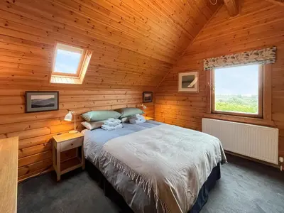 a bedroom with a bed in a wooden cabin at Bengairn in Ringford