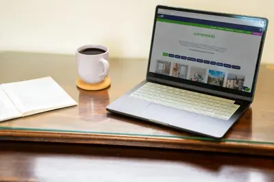 a laptop computer sitting on a desk with a cup of coffee at Panoramic Views & Spacious Living by LetMeStay in Grasmere